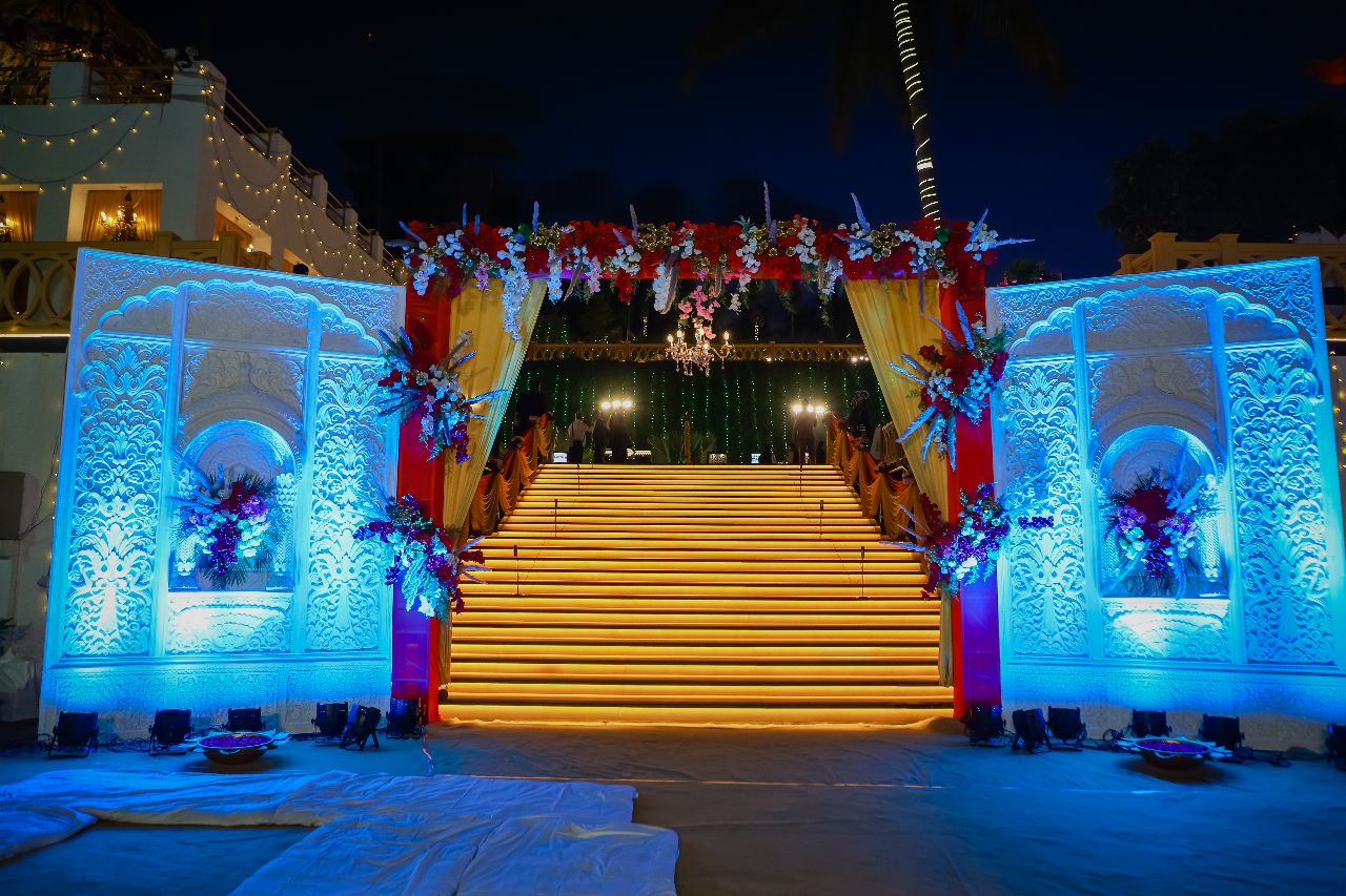 Grand entrance gate with glowing lights and floral designs, giving a warm welcoming feel.