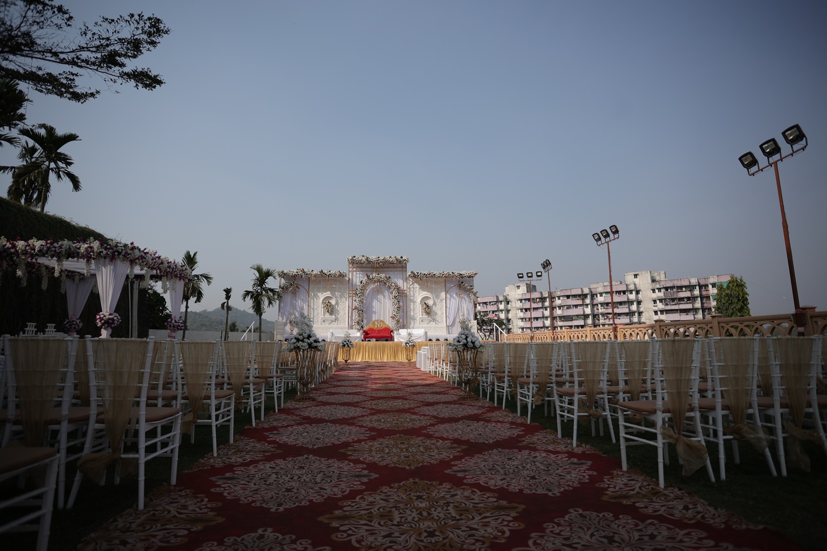 A spacious lawn set up for an event, featuring elegantly arranged tables.