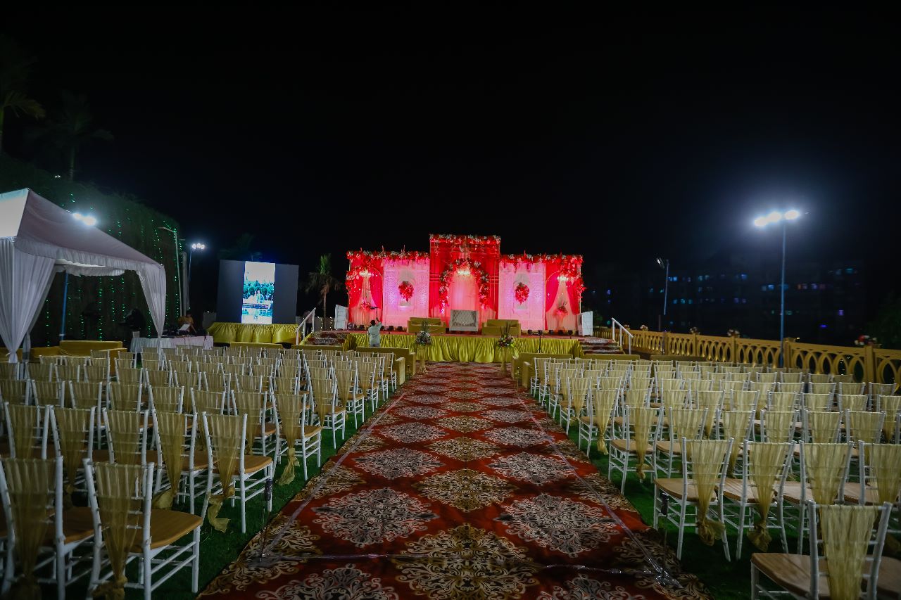 Sky deck lawn reception setup with comfortable seating, decorative lights.